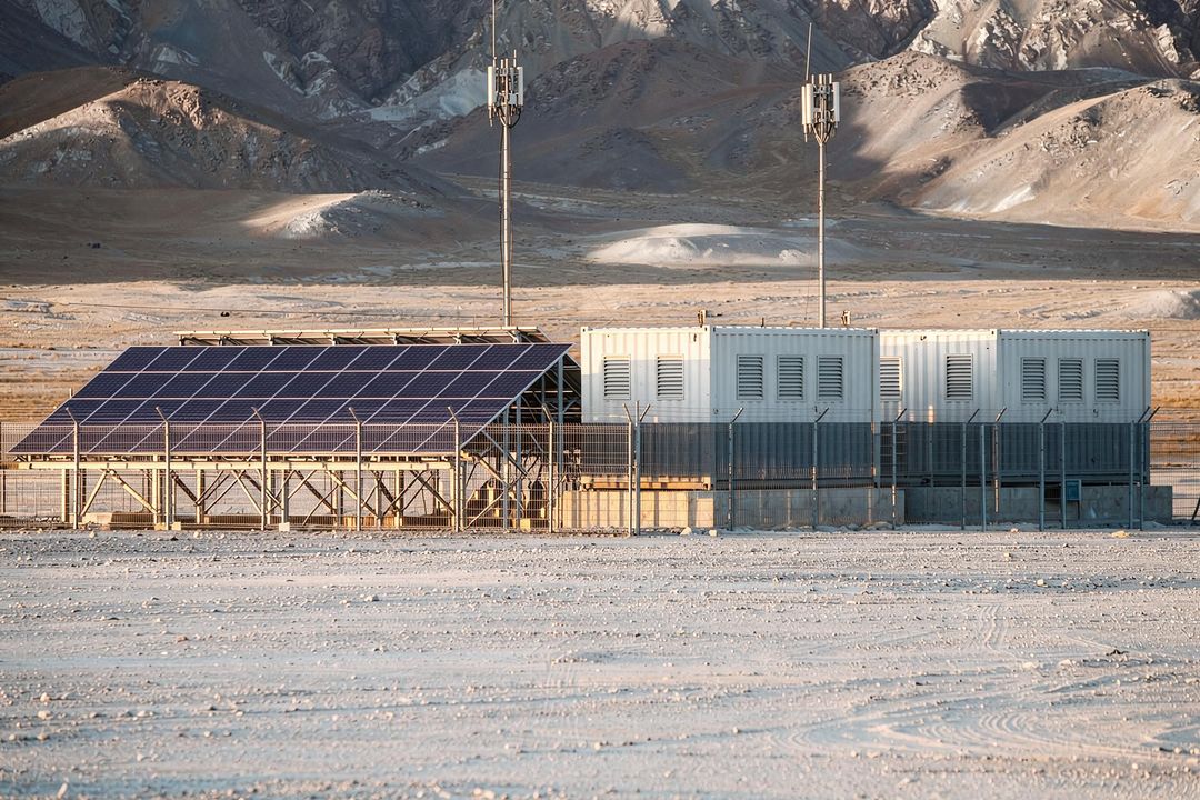 Rendered visual simulation of solar array and two containerised storage units inside a fenced remote outpost compound